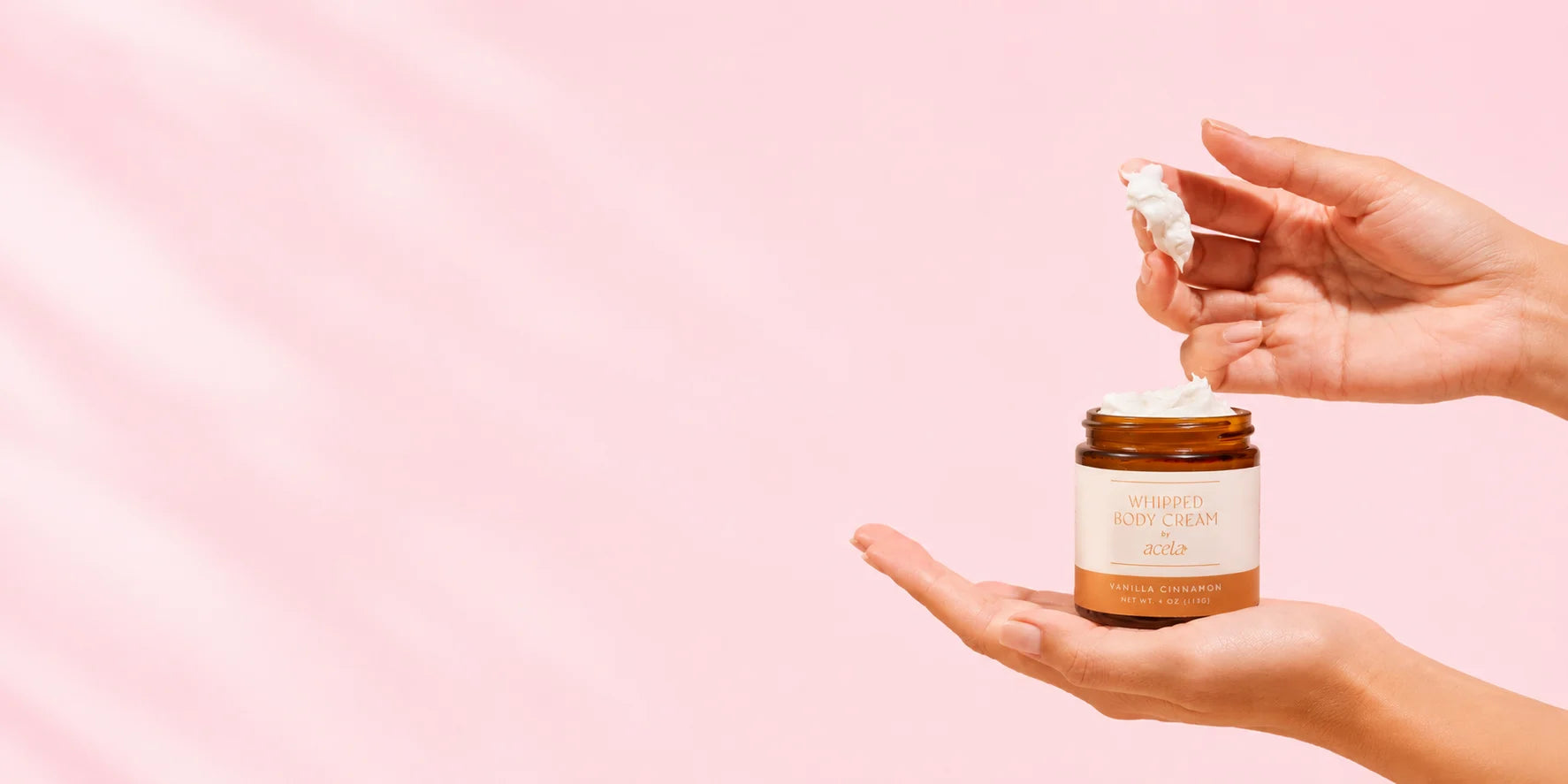 Hands holding a jar of Acela whipped body cream
